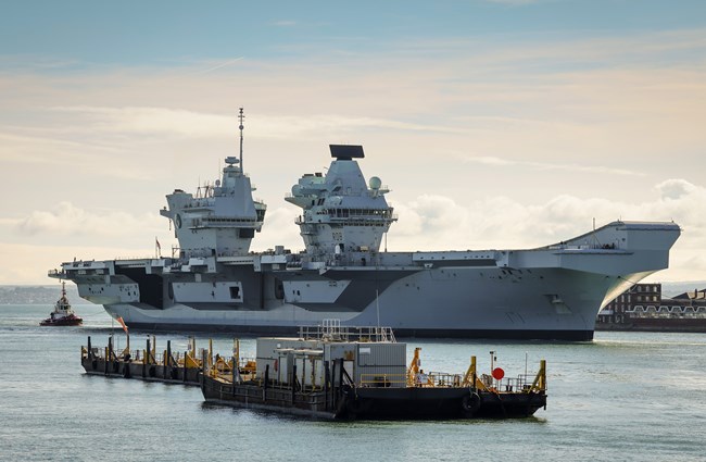 An image of the Queen Elizabeth Aircraft Carrier in Portsmouth harbour which will use BMT's REMBRANDT tug simulator for training
